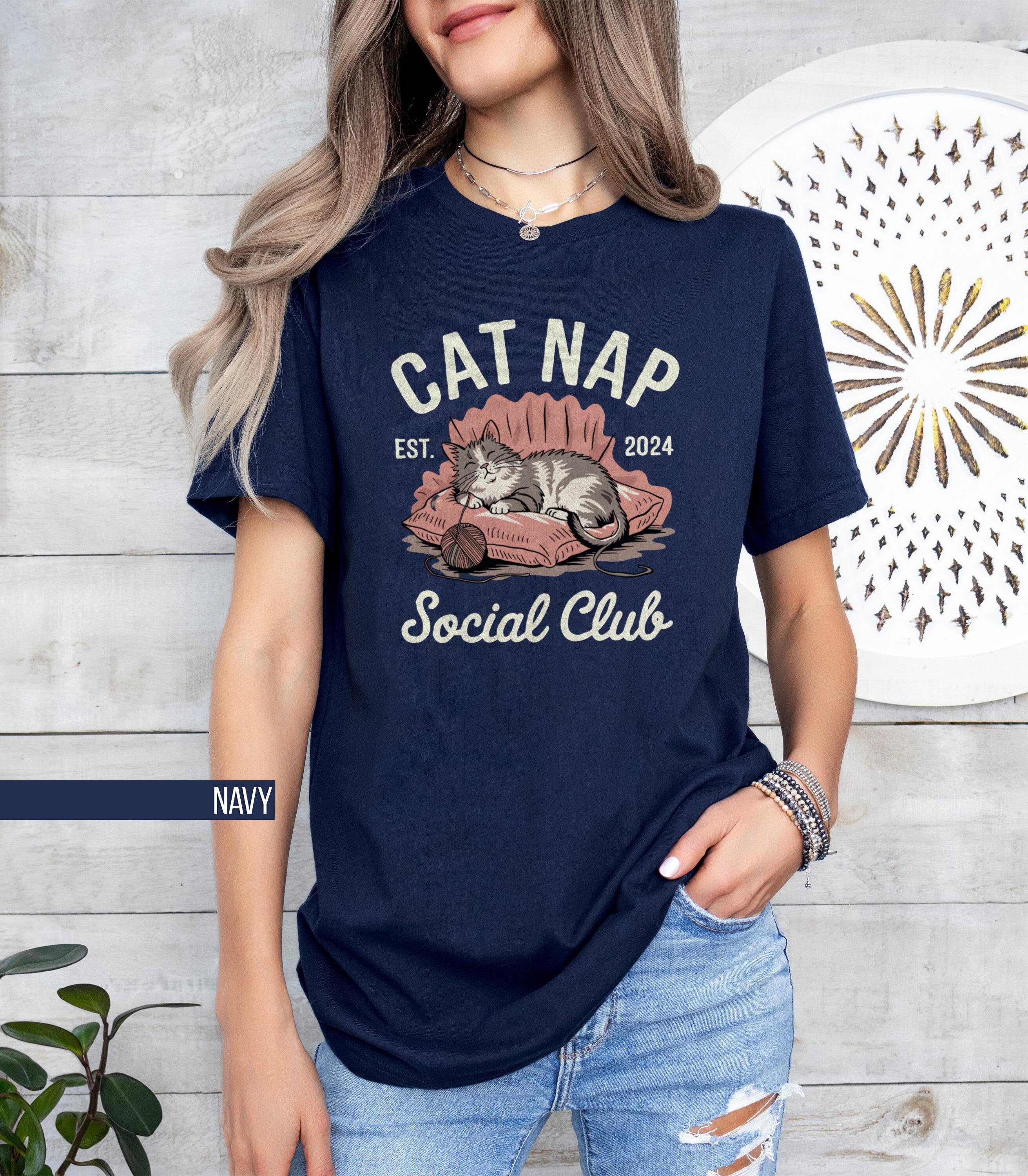 Adorable Cat Nap Social Club T Shirt Funny Cat Lover Gift Cozy Nap Time Graphic Tee Relaxing Cat Themed Shirt Cute Cat Mom T Shirt Graphic Tee – Fan Favorite · Trending Graphic Apparel